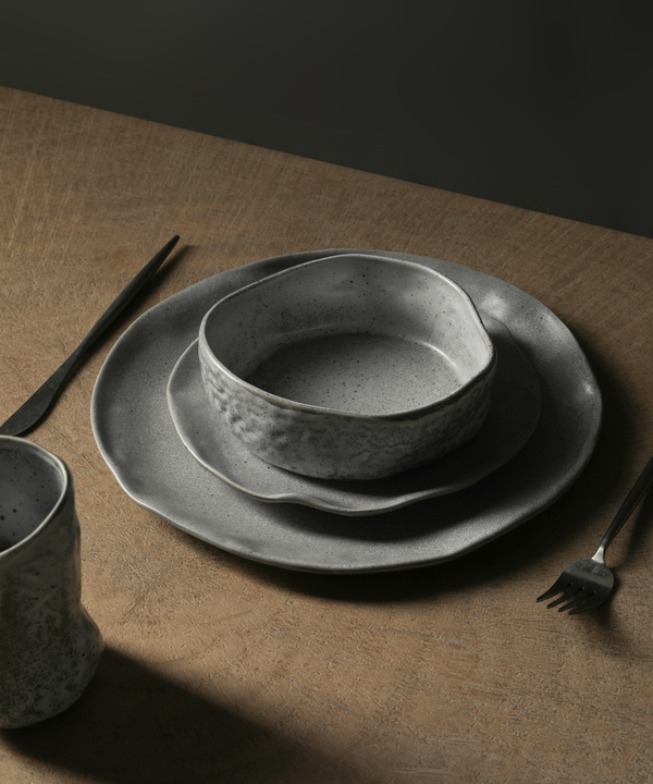 Stone by Mercer Project Nendo collection, organic bowls and plates in white with christmas decor set up on a wooden table.